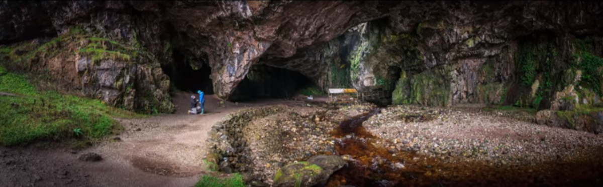 Terry getting down on one knee to propose to his girlfriend Anna in front of Smoo Cave in Scotland.