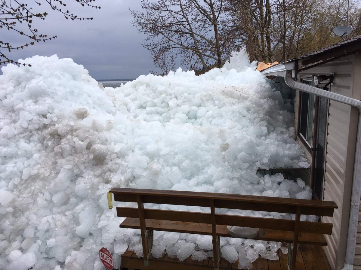 Giant piles of ice and snow push up against a cabin on Sunset Point, Lac Ste. Anne, Alta.