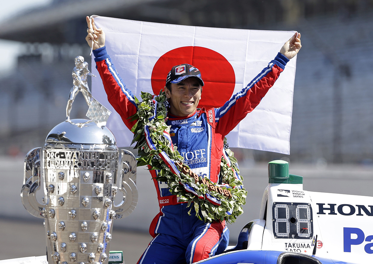 Indianapolis 500 champion Takuma Sato, of Japan, poses with the Borg-Warner Trophy during the traditional winners photo session on the start/finish line at the Indianapolis Motor Speedway in Indianapolis, Monday, May 29, 2017. 