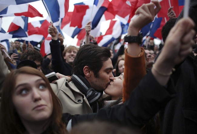 Supporters of French independent centrist presidential candidate, Emmanuel Macron kiss as they celebrate outside the Louvre museum in Paris, France, Sunday, May 7, 2017. 