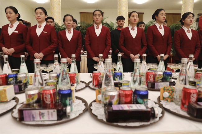 Chinese waitresses wait ahead a welcome banquet for the Belt and Road Forum at the Great Hall of the People in Beijing, Sunday, May 14, 2017. 