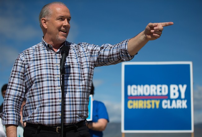 NDP Leader John Horgan gestures while standing in front of a sign reading "Ignored By Christy Clark" during a healthcare related campaign stop in Kamloops, B.C., on Tuesday May 2, 2017. A provincial election will be held on May 9.