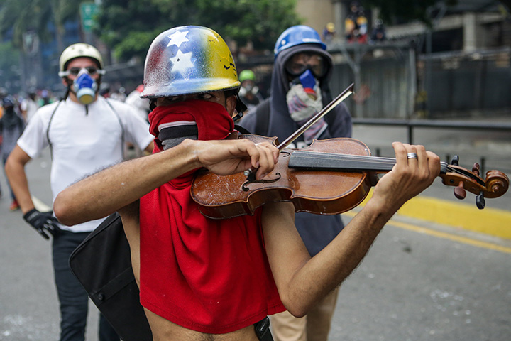 A demonstrator performs on a violin during a protest in Caracas, Venezuela, May 8, 2017.