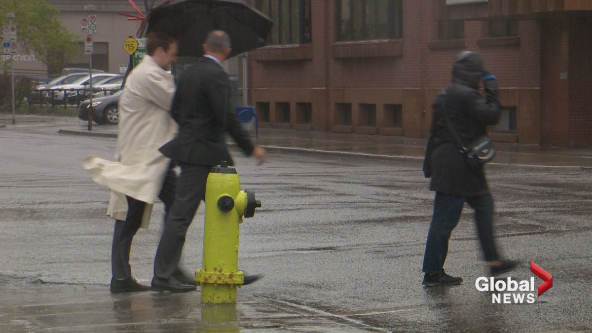 People walk through high winds and heavy rain in downtown Calgary earlier this year.