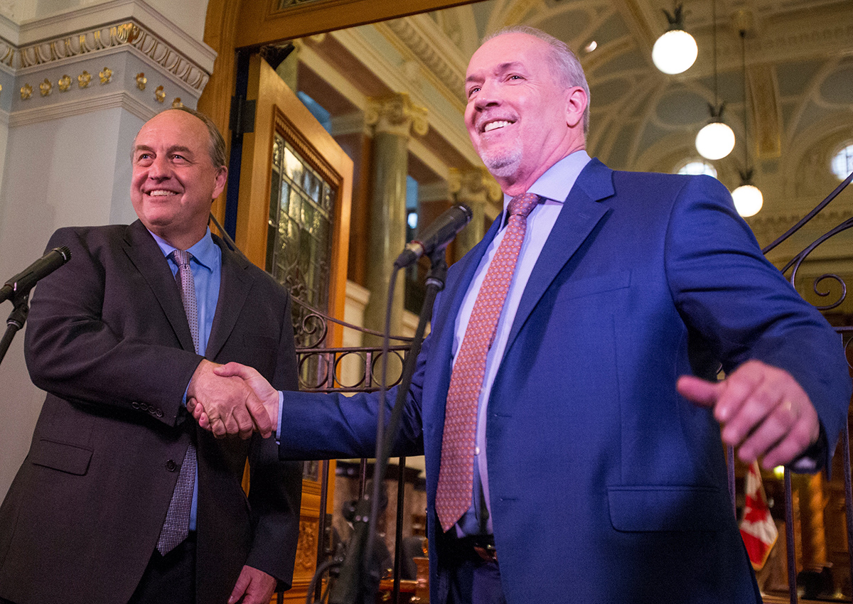 BC Green leader Andrew Weaver and BC New Democrat leader John Horgan shake hands outside the gates of the British Columbia legislature building in Victoria, British Columbia, Canada May 29, 2017.