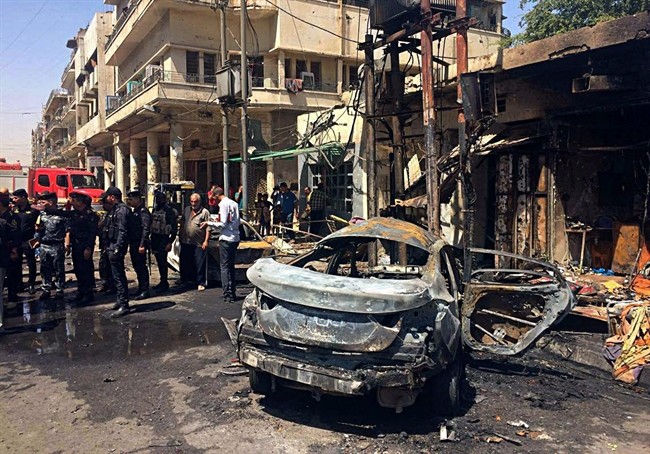 Iraqi security forces and civilians inspect the site of a deadly bomb attack, in Baghdad, Iraq, May 30, 2017.