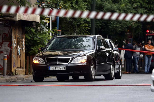 A car in which a device went off, on a central street, in Athens, Thursday, May 25, 2017. Greek police say former Prime Minister Lucas Papademos has been wounded in an explosion in a car in central Athens.
