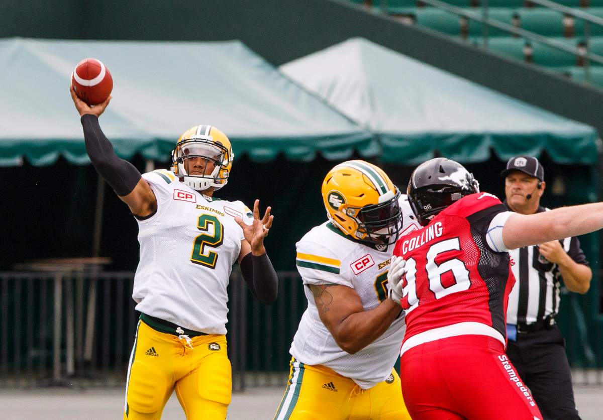 Edmonton Eskimos quarterback James Franklin (2) under pressure from Calgary Stampeders Randy Colling (96) during first half CFL pre-season action in Edmonton, Alta., on Sunday June 11, 2017. THE CANADIAN PRESS/Amber Bracken.