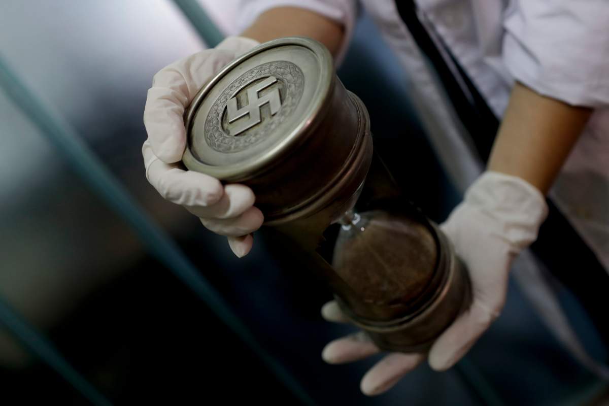 A member of the federal police holds an hourglass with Nazi markings at the Interpol headquarters in Buenos Aires, Argentina, Friday, June 16, 2017.