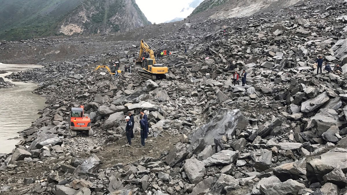 Emergency personnel and earthmoving equipment work at the site of a massive landslide in Xinmo village in Maoxian County in southwestern China's Sichuan Province, Saturday, June 24, 2017. 