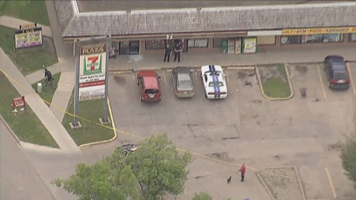 Police officers stand outside of an Edmonton 7-Eleven after a man was injured in a fight. 