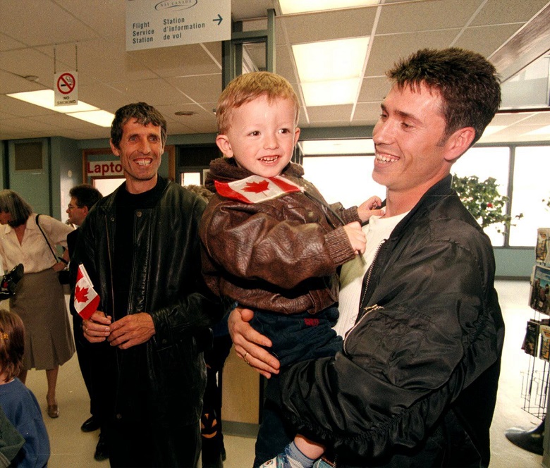 Ahmet Hoti (right) smiles as he greets his nephew llir and brother Din Hoti (left), Kosovo refugees, upon their arrival in Manitoba in 1999.