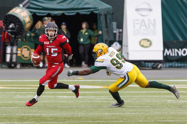Calgary Stampeders quarterback Andrew Buckley (15) dodges Edmonton Eskimos Rykeem Yates (99) during second half CFL pre-season action in Edmonton, Alta., on Sunday June 11, 2017. The Stampeders won 36-35. 