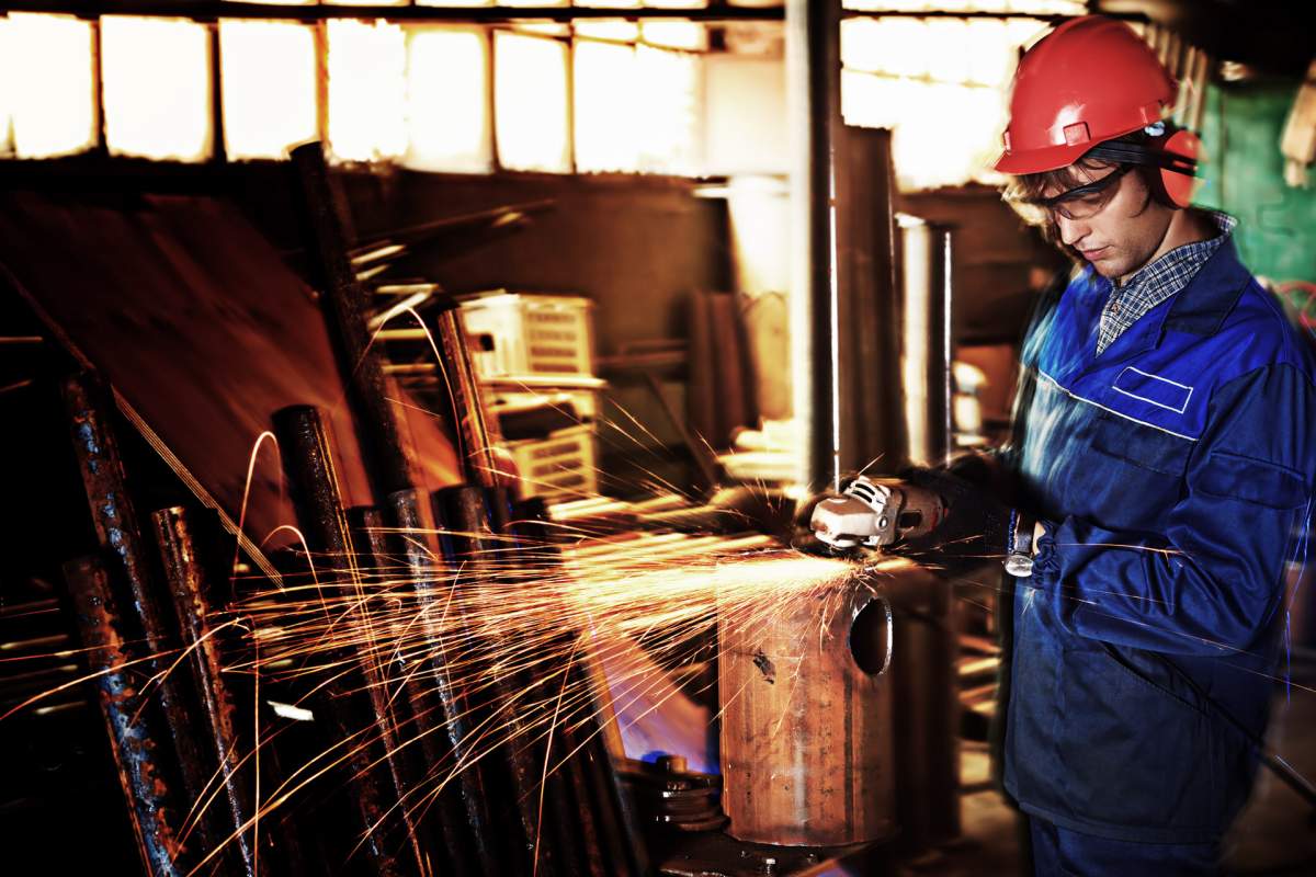 In this file photo, a man grinds metal in a workshop.