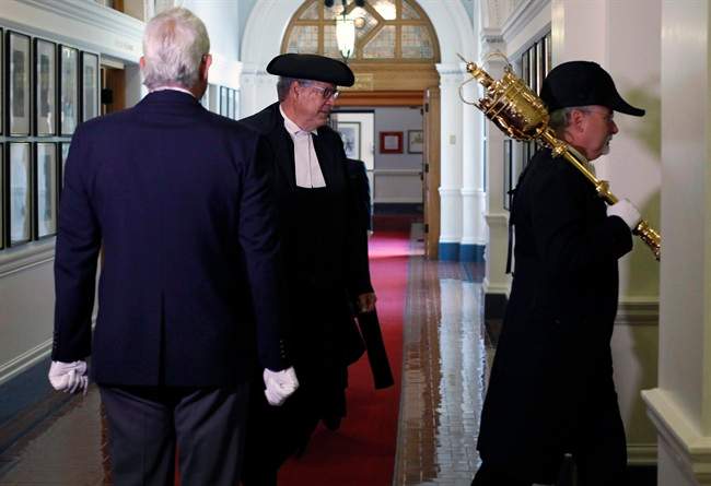 Former speaker of the B.C. legislature Steve Thomson is lead by the Sergeant-of-Arms, to start of the debate in Victoria, B.C., on Monday, June 26, 2017. 
