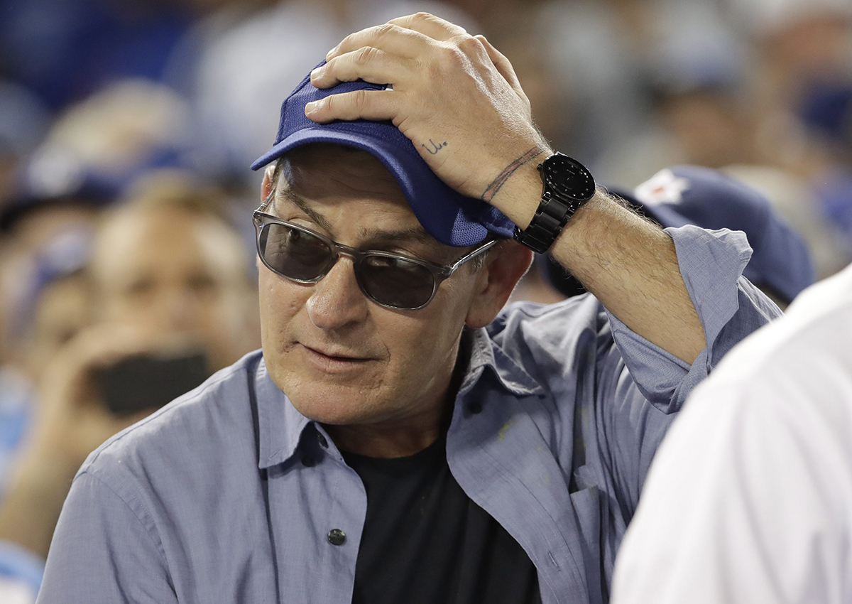 In this Oct. 19, 2016, file photo, actor Charlie Sheen reacts during the fifth inning of Game 4 of the National League baseball championship series between the Chicago Cubs and the Los Angeles Dodgers in Los Angeles. 