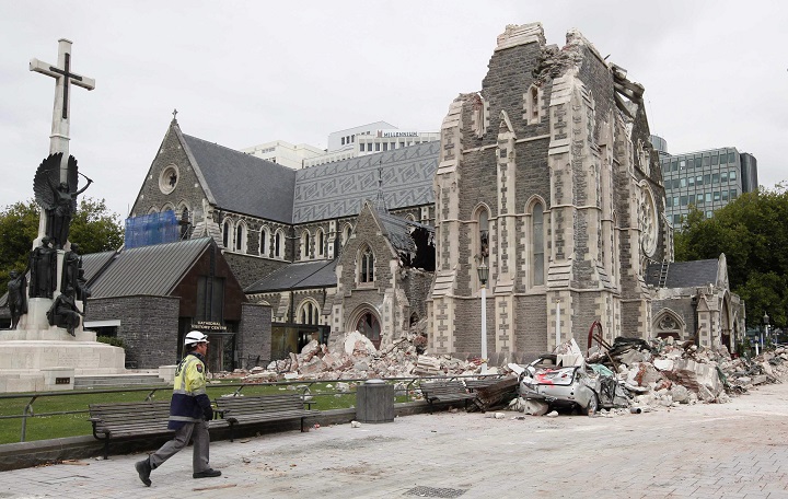 In this Feb. 26, 2011 file photo, a relief worker walks past the earthquake-damaged Christchurch Cathedral in Christchurch, New Zealand following a magnitude 6.3 earthquake.