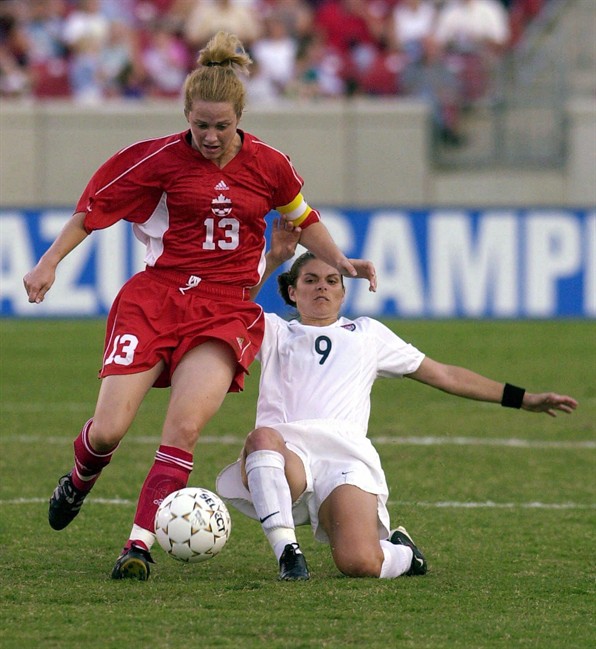 USA's Mia Hamm (9) attempts a slide tackle on Canada's Amy Walsh (13) during the first half of a women's Gold Cup match Saturday, July 1, 2000, in Louisville, Kentucky. Canada Soccer took time out to honour its own Sunday, celebrating six former players including Canada Soccer Hall of Fame inductee Walsh.