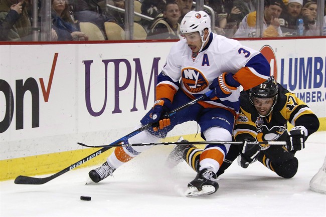 Pittsburgh Penguins' Bryan Rust (17) collides with New York Islanders' Travis Hamonic (3) during the second period of an NHL hockey game in Pittsburgh, Friday, March 24, 2017.Defenceman Hamonic was acquired by the Calgary Flames in a trade with the Islanders on Saturday.