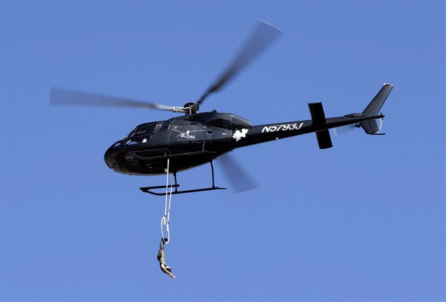 In this Oct. 11, 2015 file photo, Erendira Wallenda hangs from a helicopter as she performs before the start of the NASCAR Sprint Cup series auto race at Charlotte Motor Speedway in Concord, N.C.