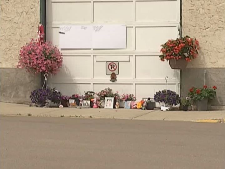 A memorial grows outside a maintenance yard in Dewberry, Alta. where a 21-year-old woman was killed by a falling lawn mower. June 15, 2017.
