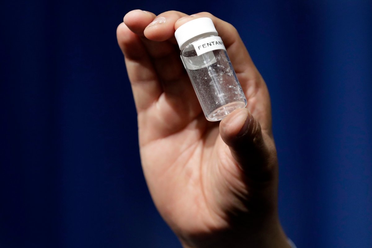 FILE - A reporter holds up an example of the amount of fentanyl that can be deadly after a news conference at DEA Headquarters in Arlington Va., June 6, 2017.