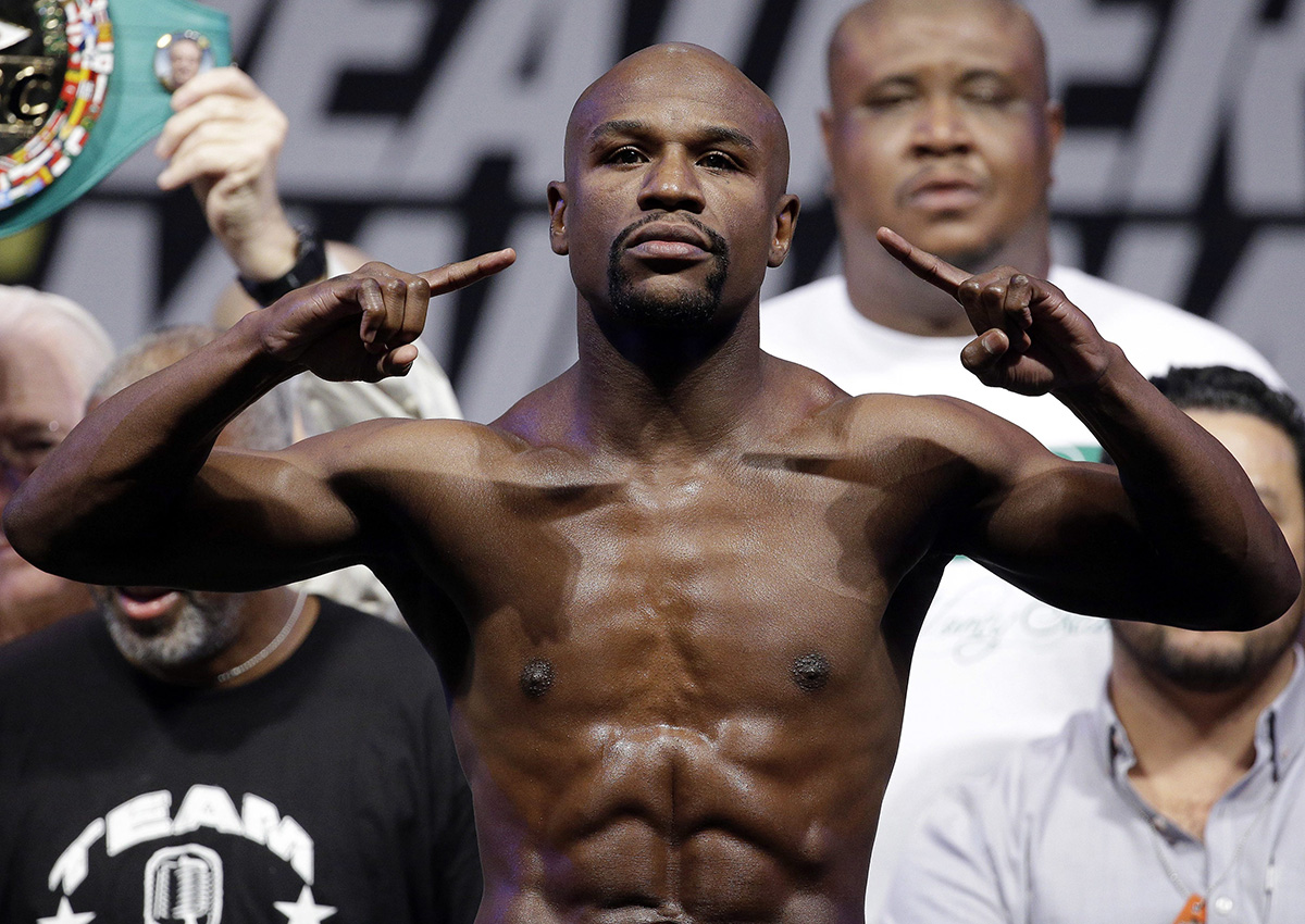  In this Sept. 12, 2014, file photo, Floyd Mayweather Jr. poses on the scale during a weigh in for a fight against Marcos Maidana in Las Vegas. Mayweather Jr. said Wednesday, June 14, 2017,  he will come out of retirement to face UFC star Conor McGregor in a boxing match on Aug. 26. 