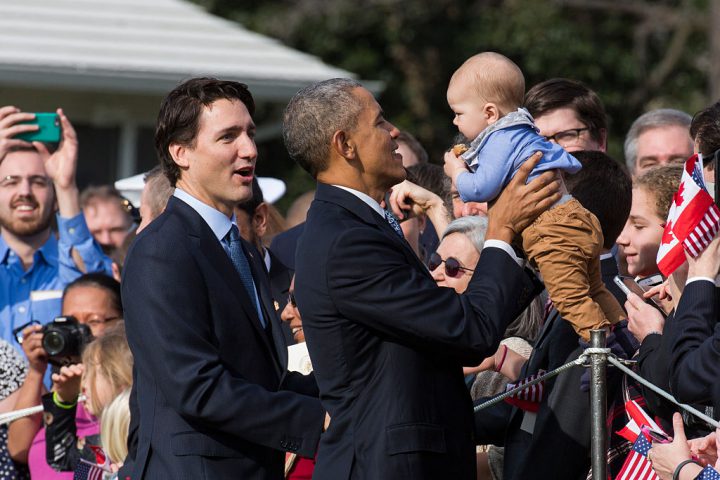 U.S. President Barack Obama holds a baby as Canadian Prime Minister Justin Trudeau looks on during an arrival ceremony on the South Lawn of the White House, March 10, 2016.