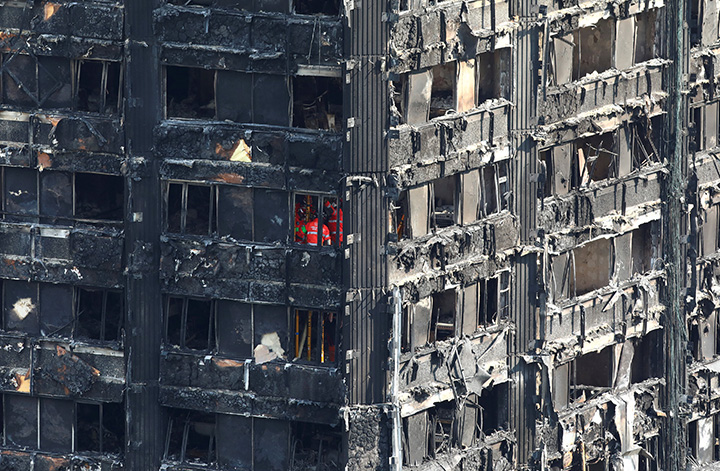 Members of the emergency services work inside burnt out remains of the Grenfell apartment tower in North Kensington, London, Britain, June 18, 2017.
