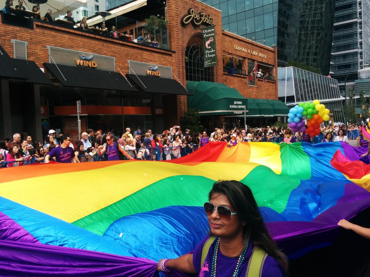 Marchers carry a giant flag at the 2016 Vancouver Pride Parade.