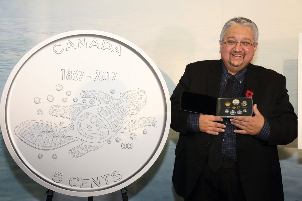 Nova Scotia artist Gerald Gloade poses with his design which will grace a new 5-cent coin that celebrates Canada's 150th anniversary.