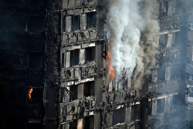 Parts of the building still burn hours after a deadly blaze at a high rise apartment block in London, Wednesday, June 14, 2017.
