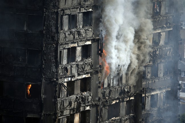 Parts of the building still burn hours after a deadly blaze at a high rise apartment block in London, Wednesday, June 14, 2017.