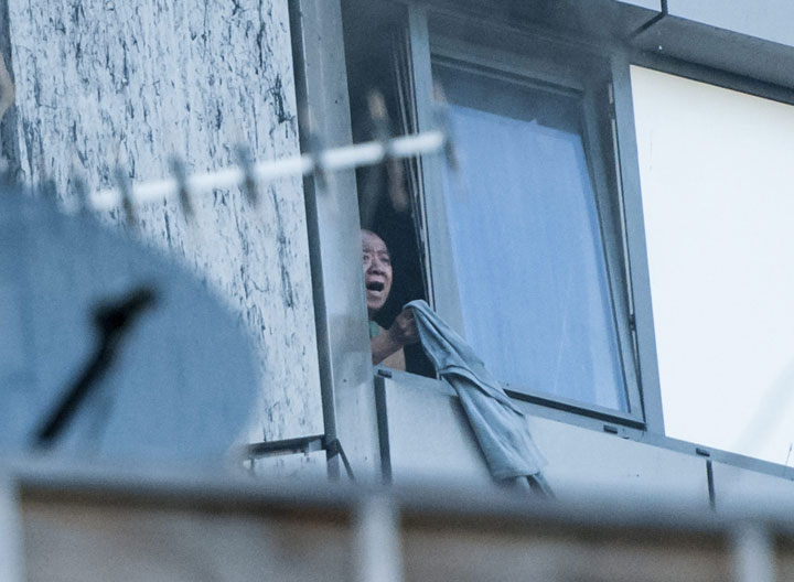 A distressed, trapped man waves an item of clothing