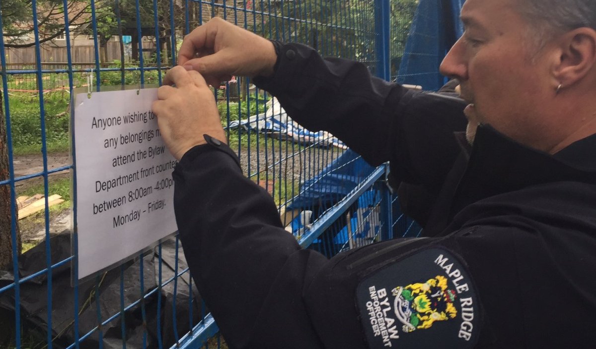 A Bylaw officer posts a notice outside the homeless camp known as "Anita's Place.".