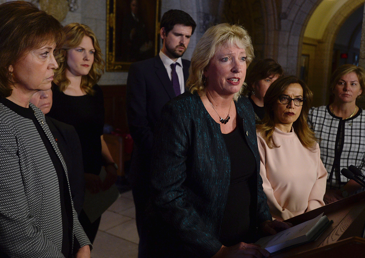 Chair of the House of Commons Standing Committee on the Status of Women Marilyn Gladu speaks surrounded by committee members after tabling the report entitled "Taking Action to End Violence Against Young Women and Girls in Canada," Monday, March 20, 2017 in Ottawa.