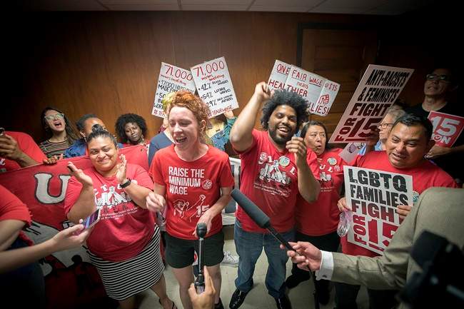 Minneapolis city council candidate Ginger Jentzen, centre, celebrates with other supporters of the $15 minimum wage increase after it was passed by city council on June 30, 2017.