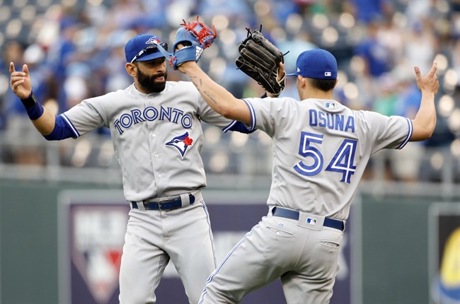 Toronto Blue Jays' Jose Bautista, left, and pitcher Roberto Osuna, right, celebrate at the end of a baseball game against the Kansas City Royals at Kauffman Stadium in Kansas City, Mo., Sunday, June 25, 2017.