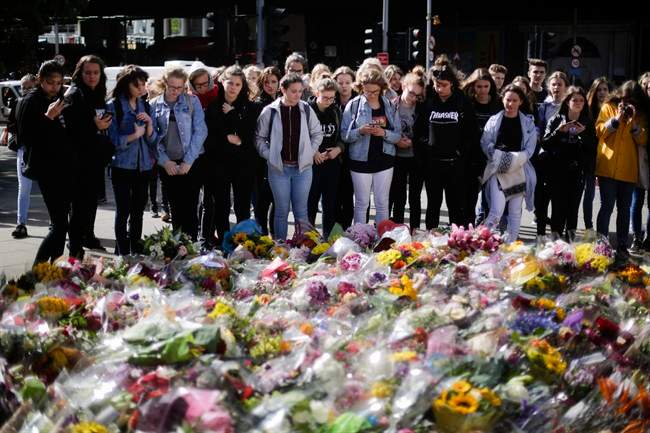 People look at floral tributes on London Bridge, Wednesday, June 7, 2017.