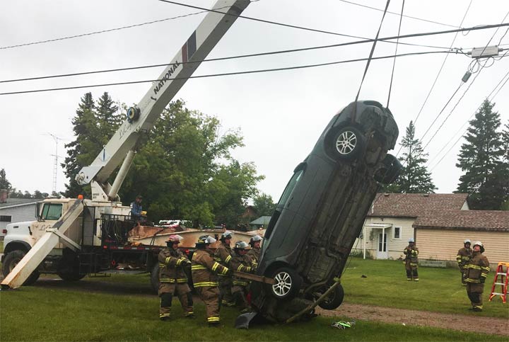 A crane was able to remove a car balancing on guide wires with the help of Nipawin, Sask., firefighters.