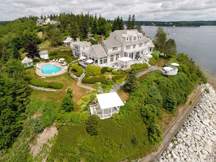 The 3.25-acre family estate features an outdoor pool, 2,400 sq.- ft. of decks, and a 130-ft. wharf.