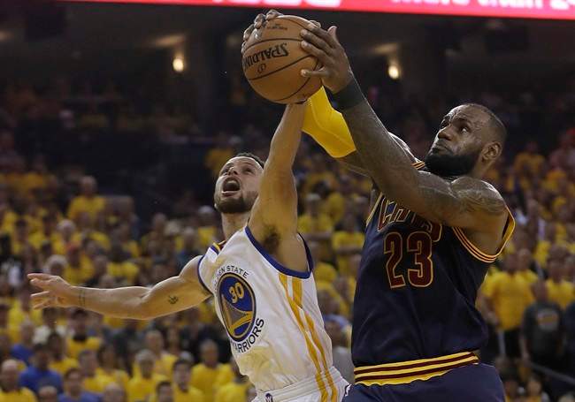 Cleveland Cavaliers forward LeBron James (23) grabs a rebound against Golden State Warriors guard Stephen Curry (30) during the first half of Game 1 of basketball's NBA Finals in Oakland, Calif., Thursday, June 1, 2017.