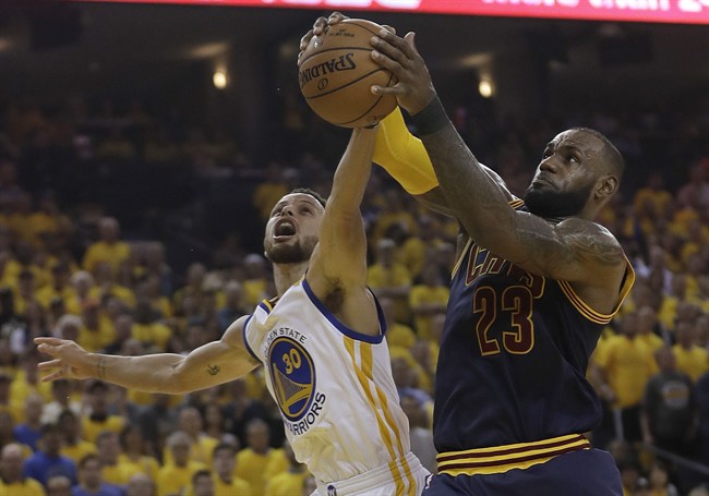 Cleveland Cavaliers forward LeBron James (23) grabs a rebound against Golden State Warriors guard Stephen Curry (30) during the first half of Game 1 of basketball's NBA Finals in Oakland, Calif., Thursday, June 1, 2017.