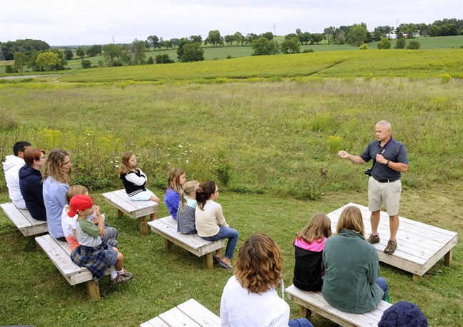 In this Aug. 26, 2015 photo, Jim Reding explains the history of the Land Lab classroom at Granville Intermediate School in Granville, Ohio. Reding, a high school science teacher said climate change is an issue that will affect his students' lives and he wants them to think critically and have civil, reasoned conversations about it.