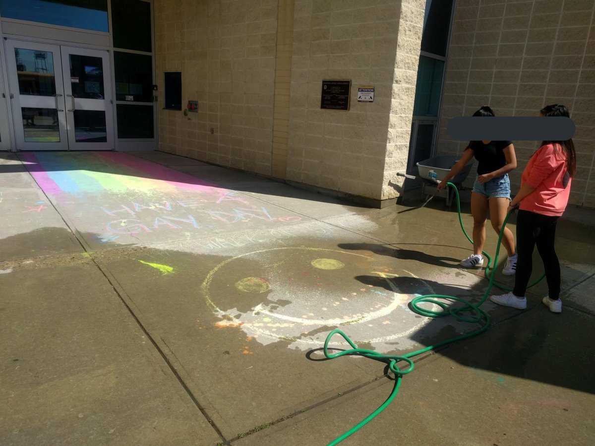 Students hose a chalk rainbow off the sidewalk outside Blessed Oscar Romero High School on June 6, 2017.