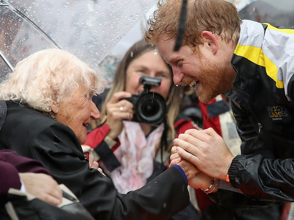 Prince Harry reunites with 97-year-old fan in the pouring rain - image