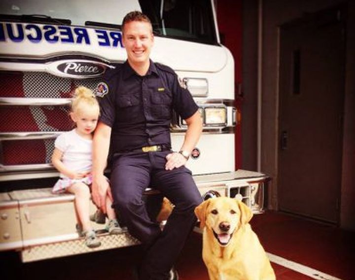 Kurt Stenberg, a Red Deer firefighter/EMT who chased down a school bus in Red Deer earlier this week that was being driven by an allegedly drunk woman, is shown in a handout photo with daughter Kate and dog Cooper. Stenberg says he was compelled to spring into action earlier this week when he saw a school bus on his street hit a tree and speed-limit sign and then keep driving.