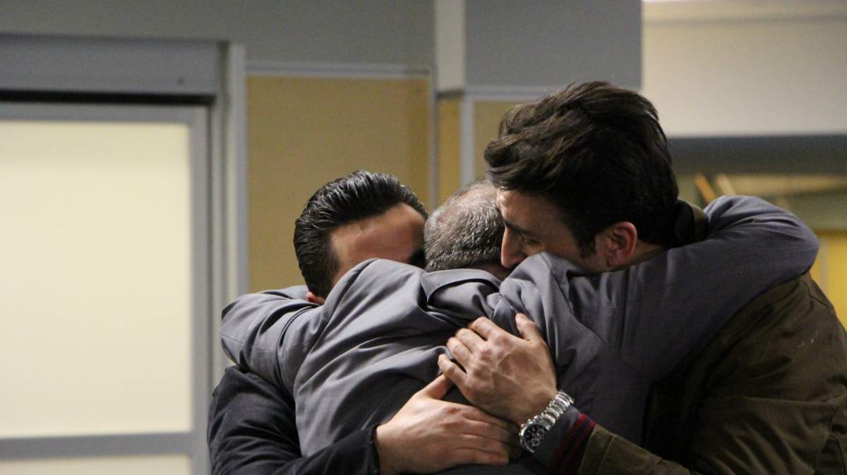 Burnaby resident Mohamed al-Homsi embraces his two refugee sons as they arrive at YVR airport, December 10, 2015.