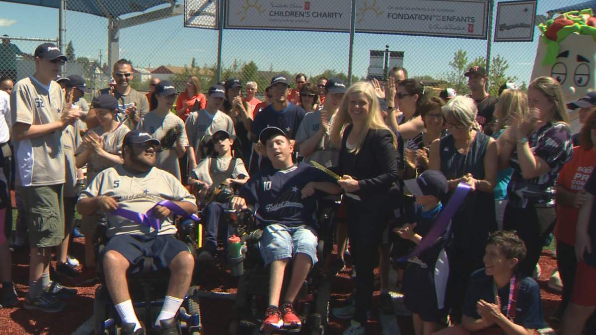 People smile for the camera at the opening of the Field of Dreams baseball field for people with cognitive and physical disabilities in Moncton on Monday, June 26, 2017.