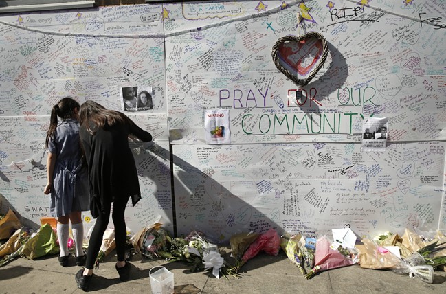 People write messages on a wall for the victims and in support for those affected by the massive fire in Grenfell Tower, in London, Thursday, June 15, 2017. 